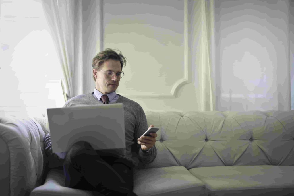 a busy rich man sitting on the chair and looking at the phone to chat on online dating site